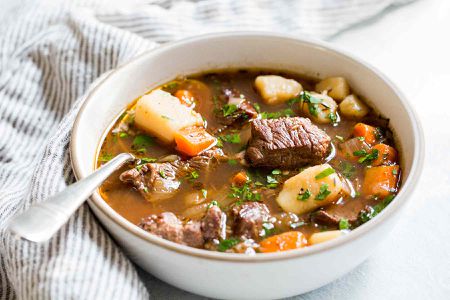 Irish stew with beef, carrots, and potatoes, Guinness and wine served in a bowl