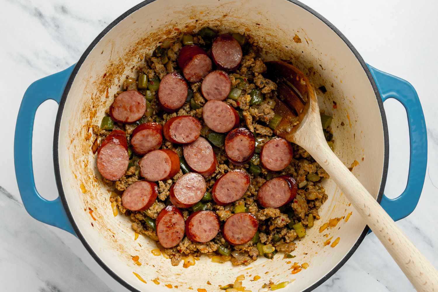 Andouille Sausage Added to Dutch Oven for Cajun Dirty Rice Recipe
