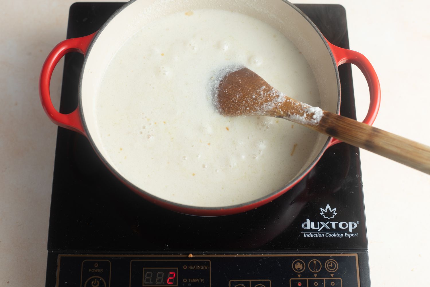 Overhead view of a dutch oven with ingredients to make coconut poached fish with bok choy, ginger, and lime