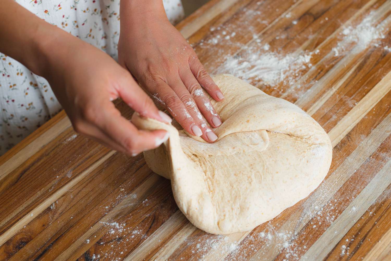 Shaping dough on a counter to make spiced sourdough bread shaped like a pumpkin