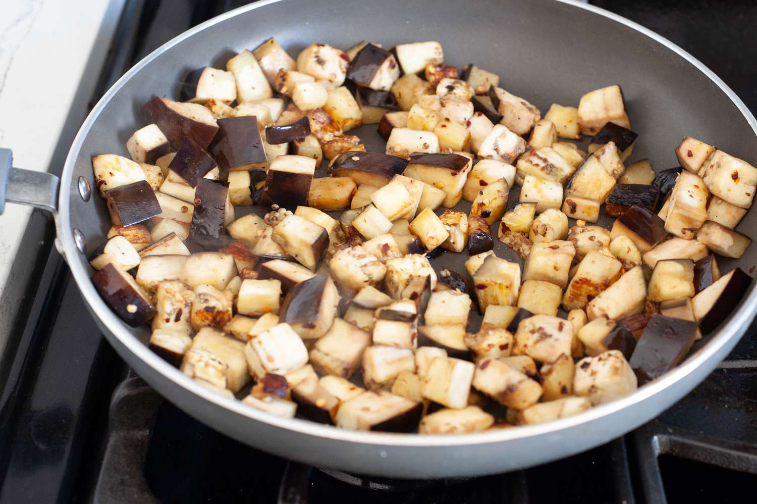 Sautéed Eggplant with Garlic and Parmesan in a Skillet on a Stove