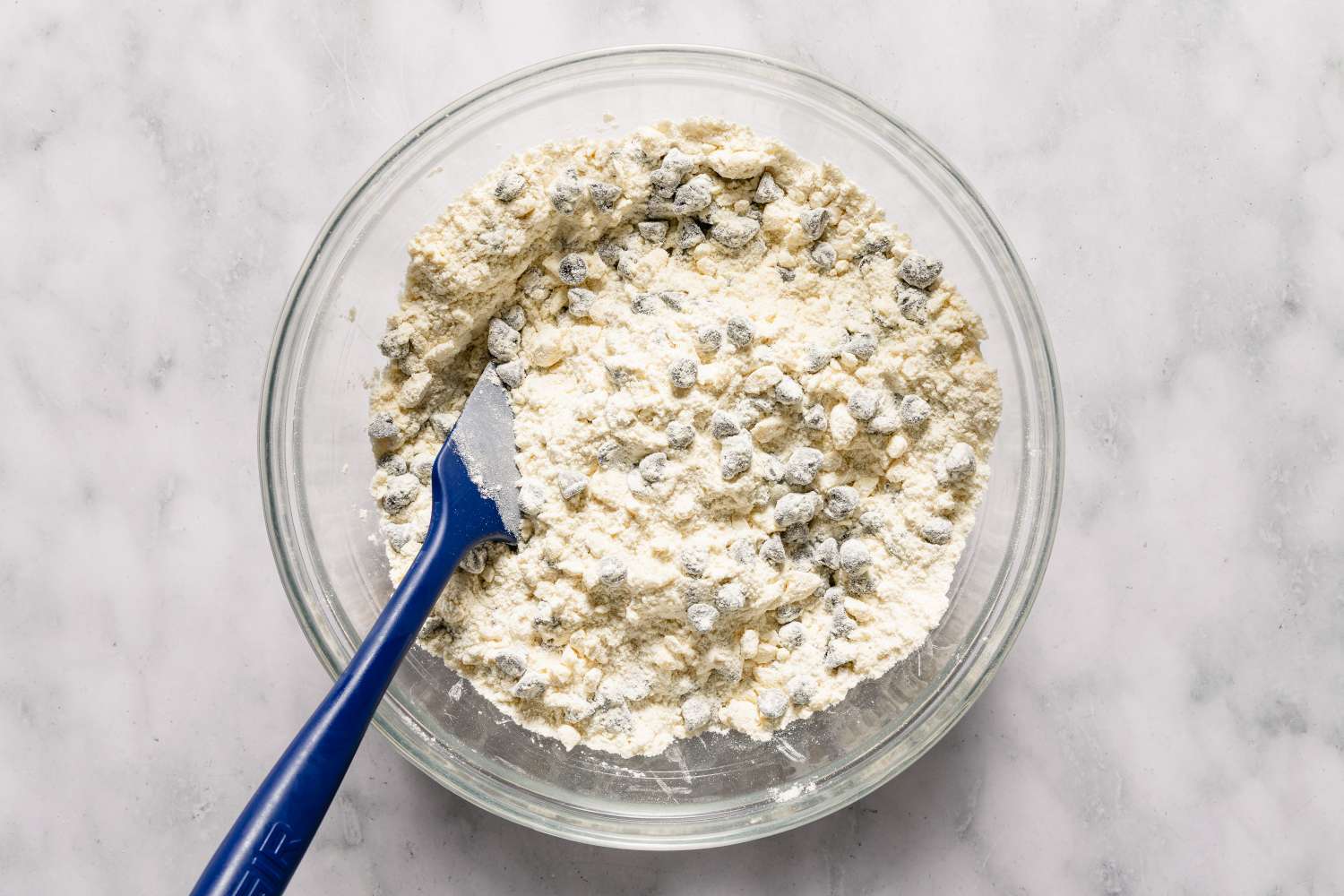 Bowl of scone dough with chocolate chips and a mixing spatula