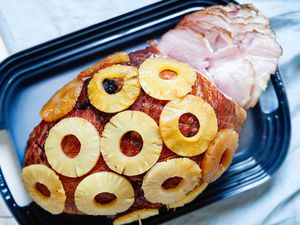 How to Cook a Ham Bone-In - partially sliced ham covered in pineapple rings