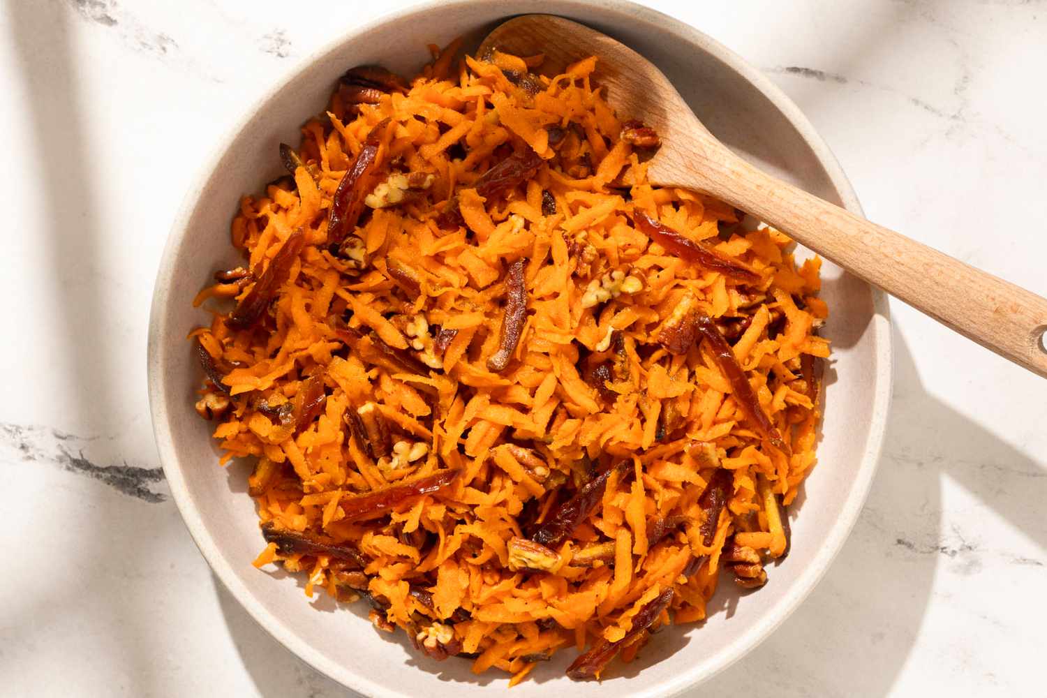 Shredded Carrot Salad in a large bowl with a wooden spoon
