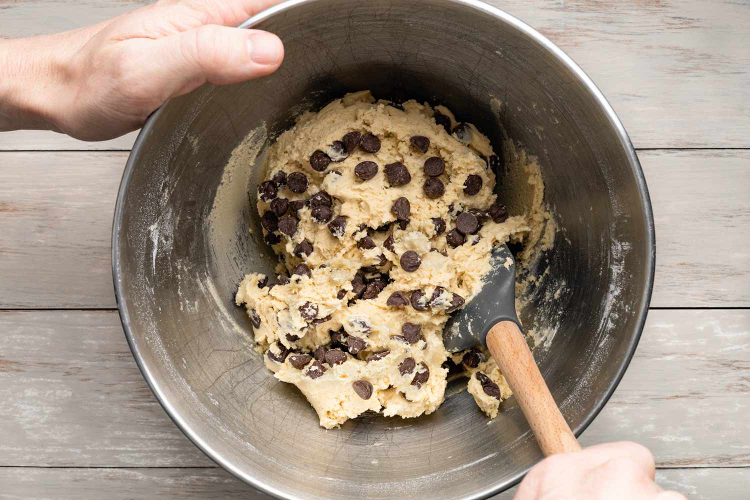 Hand Mixing Chocolate Chips in Cookie Cake Dough Using a Spatula