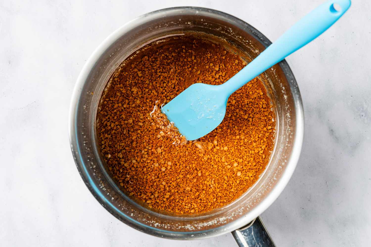 latik (coconut sprinkles) and coconut oil in a pot for biko (Filipino sticky rice cake) recipe