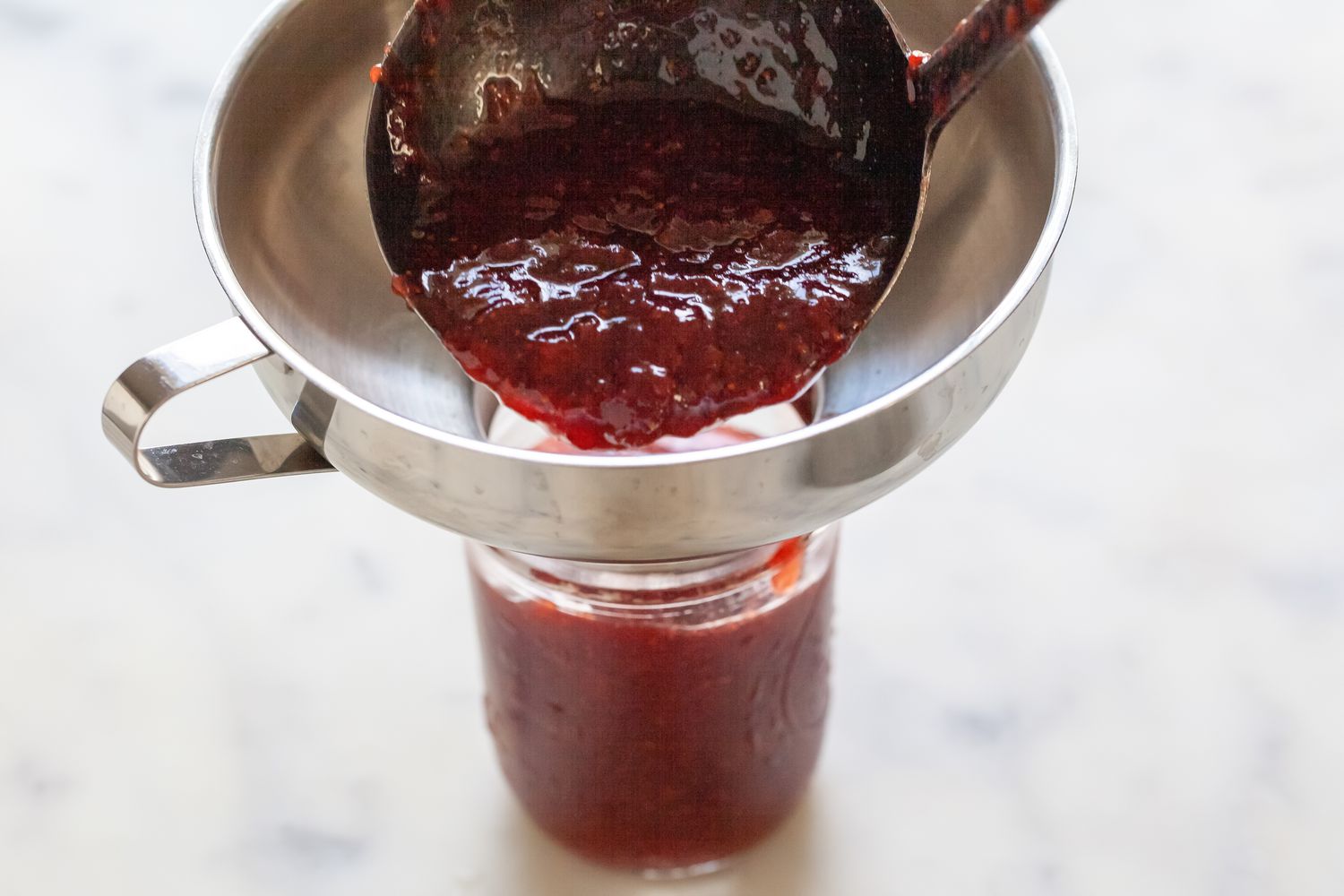 Funneling Strawberry Jam into Jar