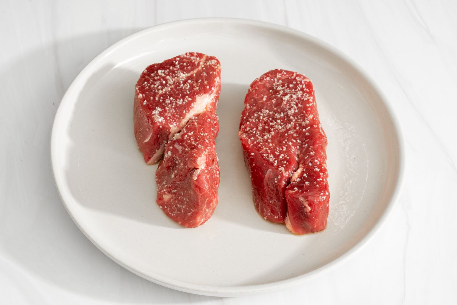 Raw filet mignon steaks salted and on a plate