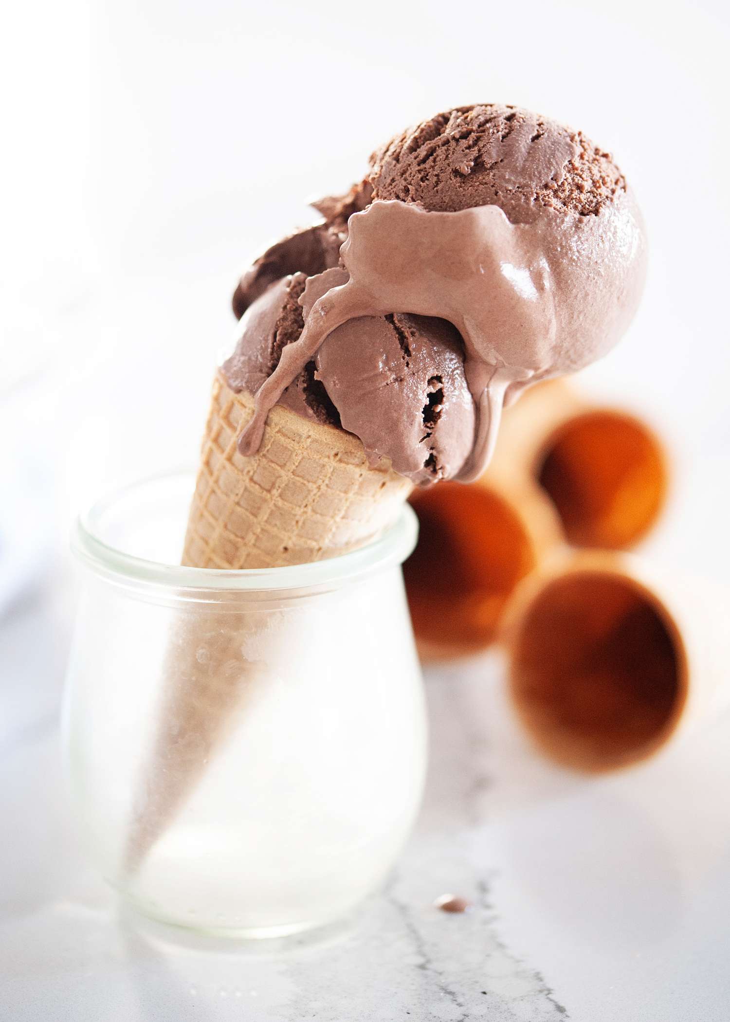 Double scoop of chocolate ice cream cone set in a dish.