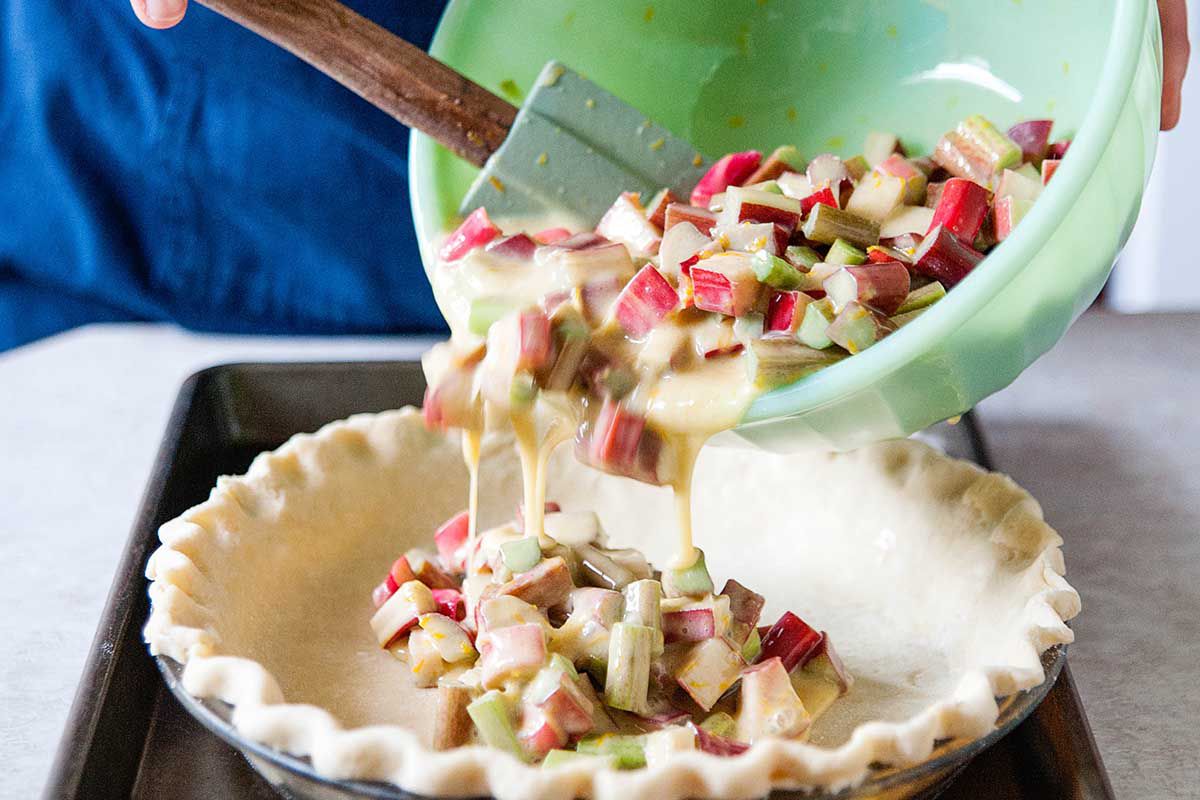 Easy Rhubarb Custard Pie - pouring rhubarb into pie