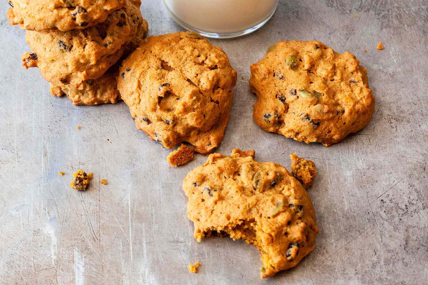 Pumpkin cookies on a counter with a glass of milk