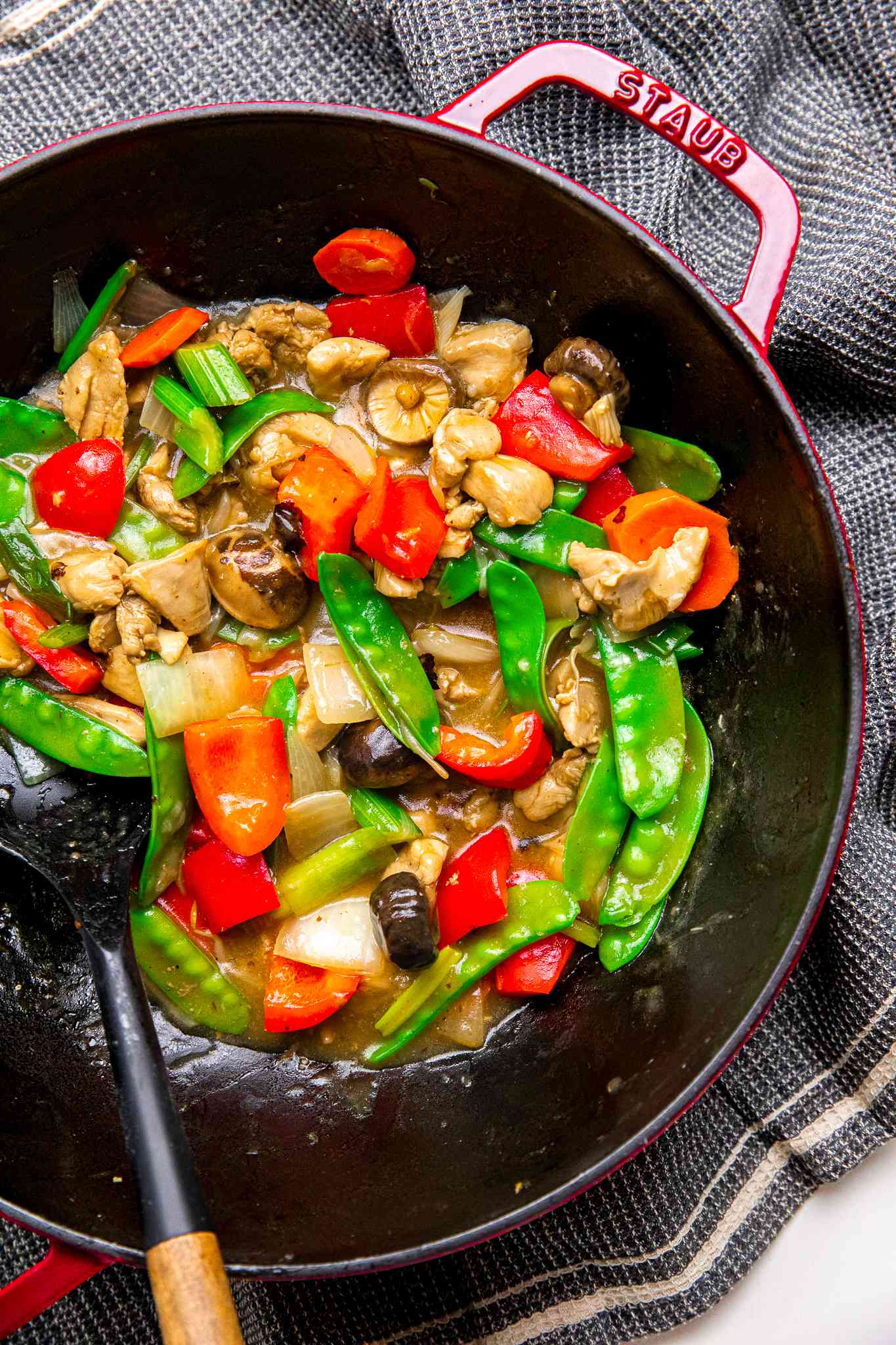 Chop Suey in a Staub Wok With a Spatula on a Grey Kitchen Towel