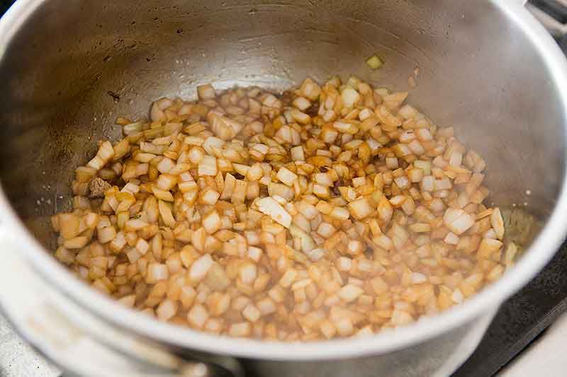 Sautéed onions in pan for lamb stew