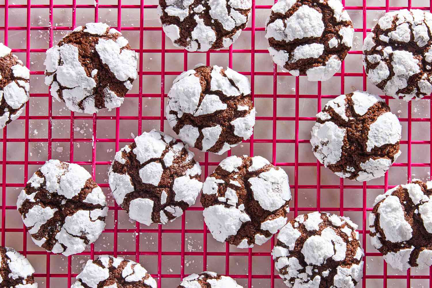 Chocolate crinkle cookies on a hot pink cooling rack