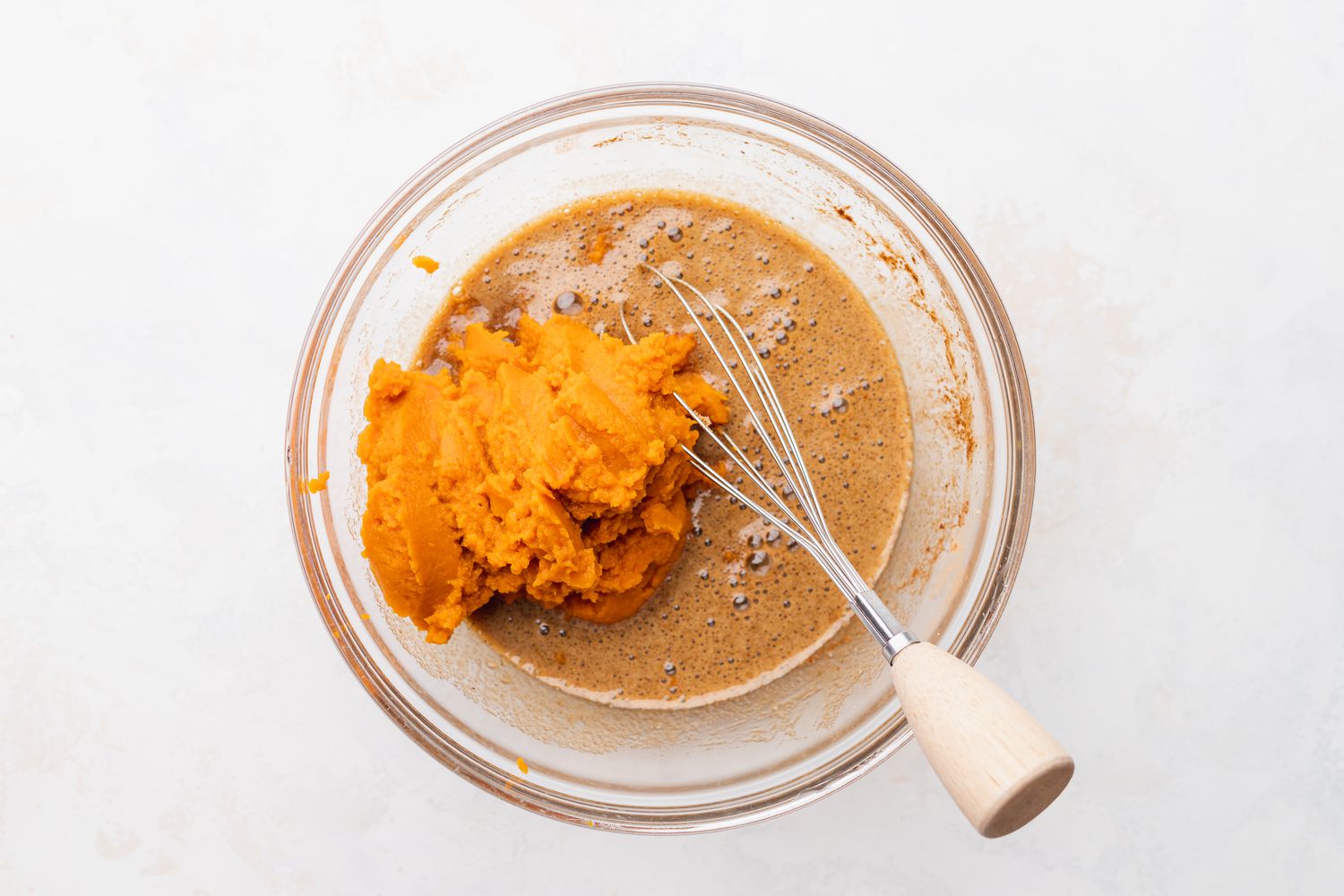 Pumpkin Puree Added to Bowl with a Whisk for Pumpkin Pie Recipe