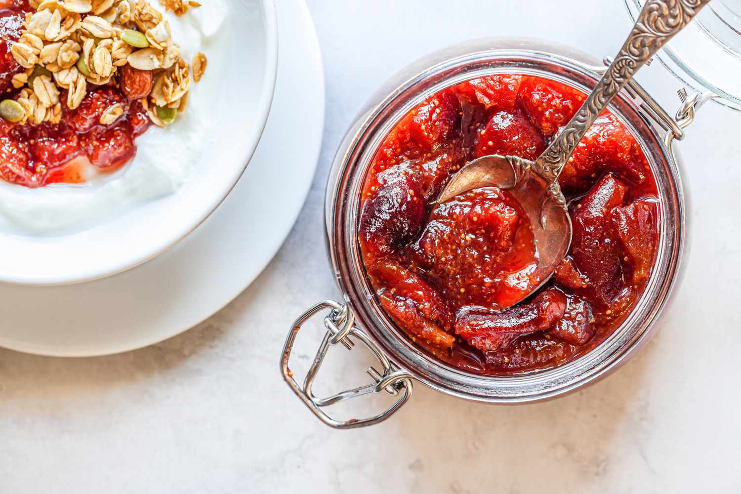 Fig Preserves in a Jar with a Spoon Next to a Bowl of Yogurt with Preserve and Oats