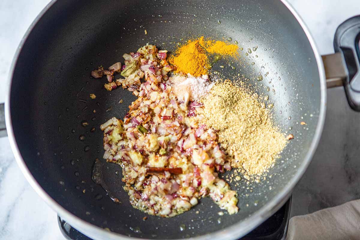 Indian Chana Masala Recipe - oil, pisces, onion in pan