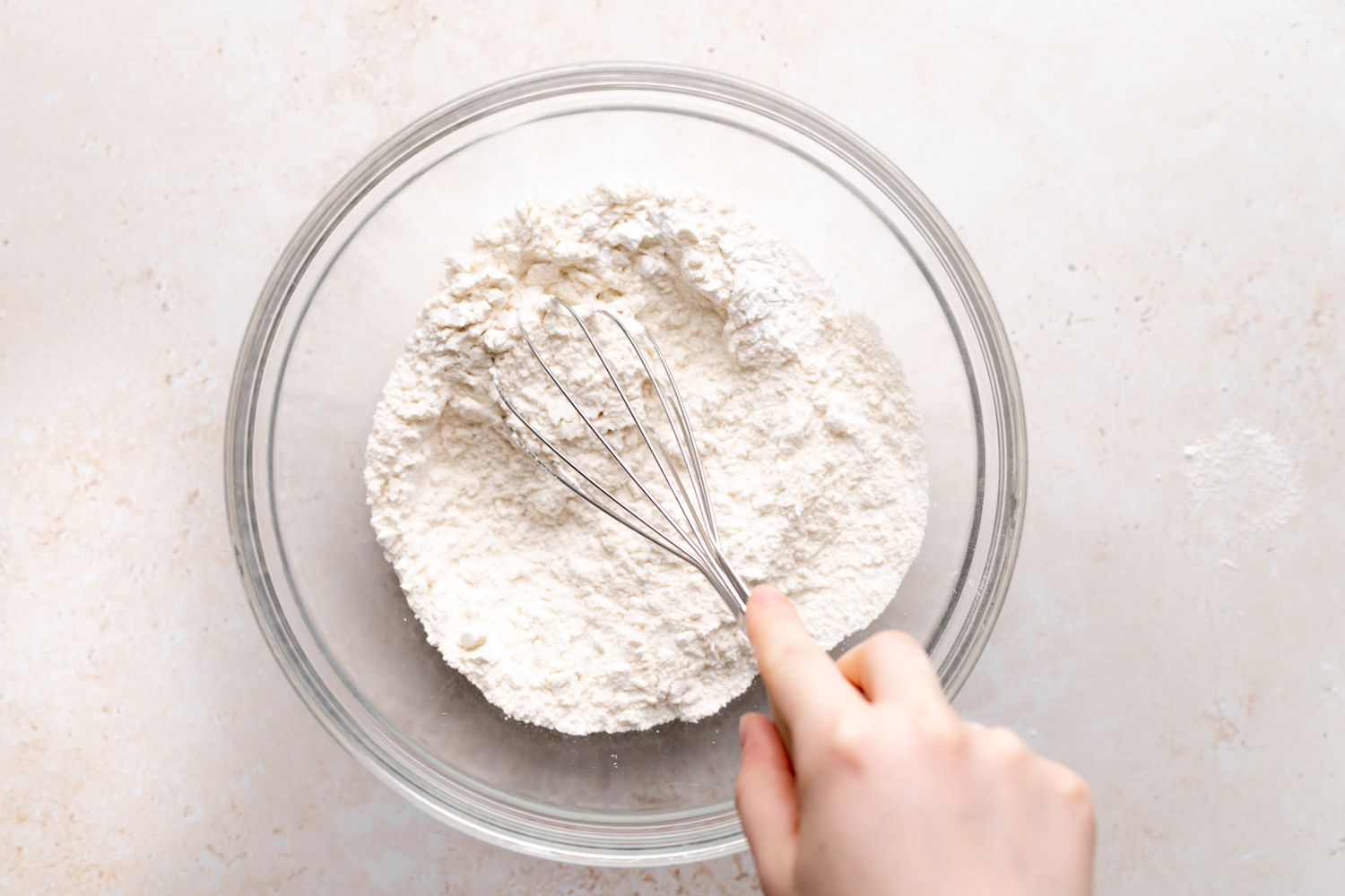 Whisking dry ingredients to make a fresh cherry cake recipe.