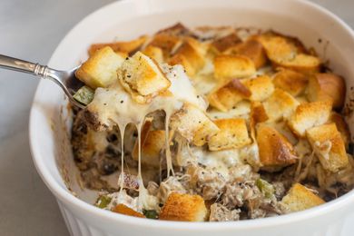 Spoon of Philly cheesesteak lifted from casserole.