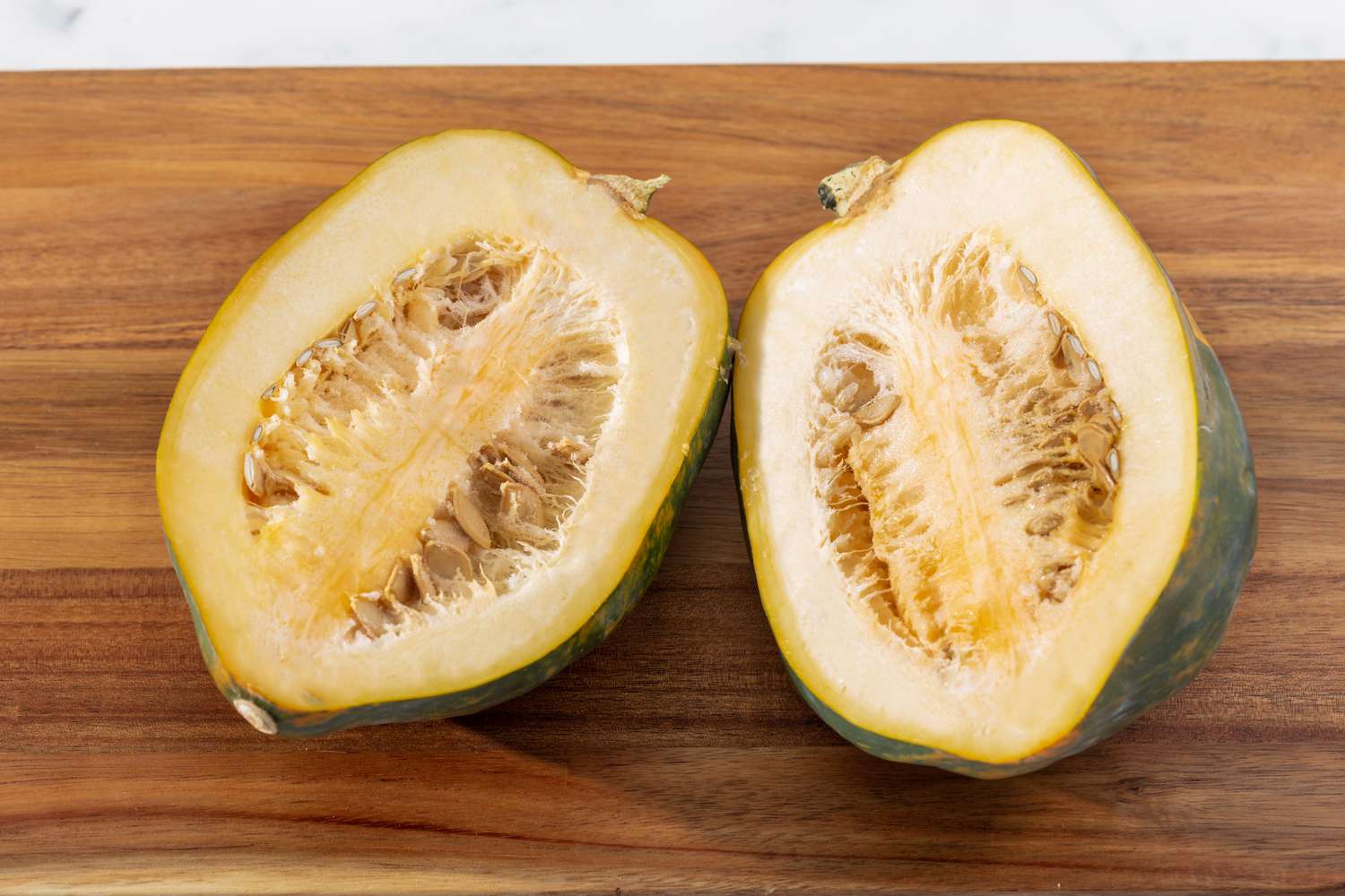 Sliced acorn squash on a cutting board.