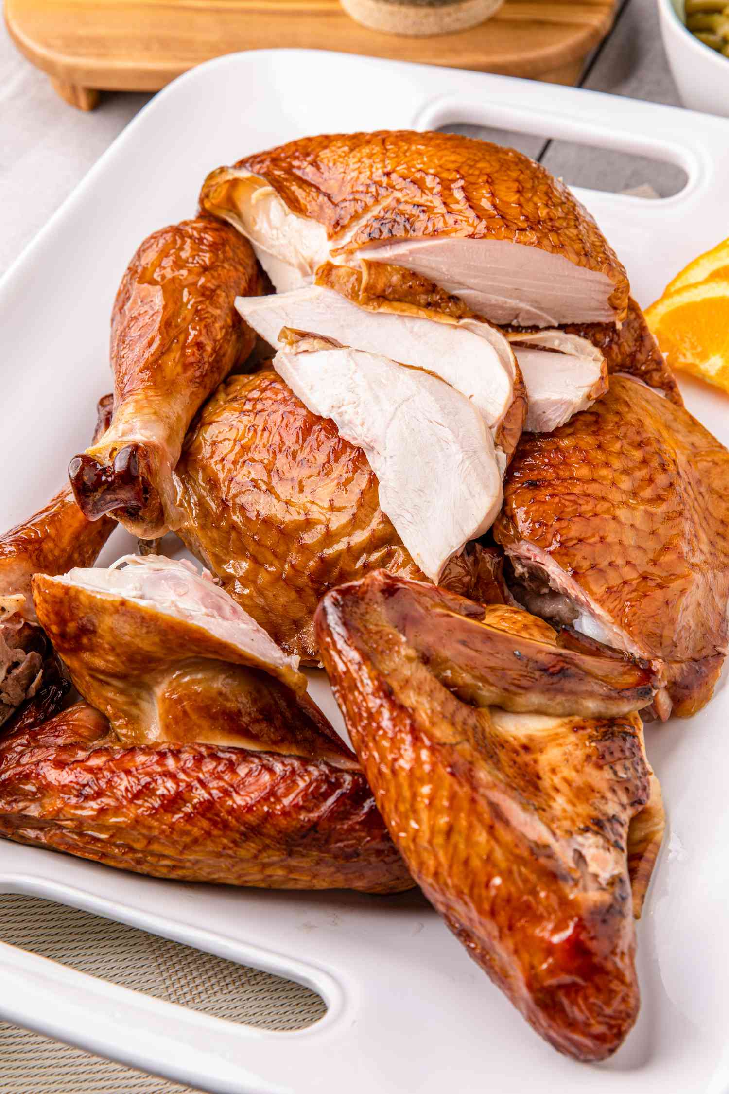 Citrus-brined smoked turkey carved on a platter.