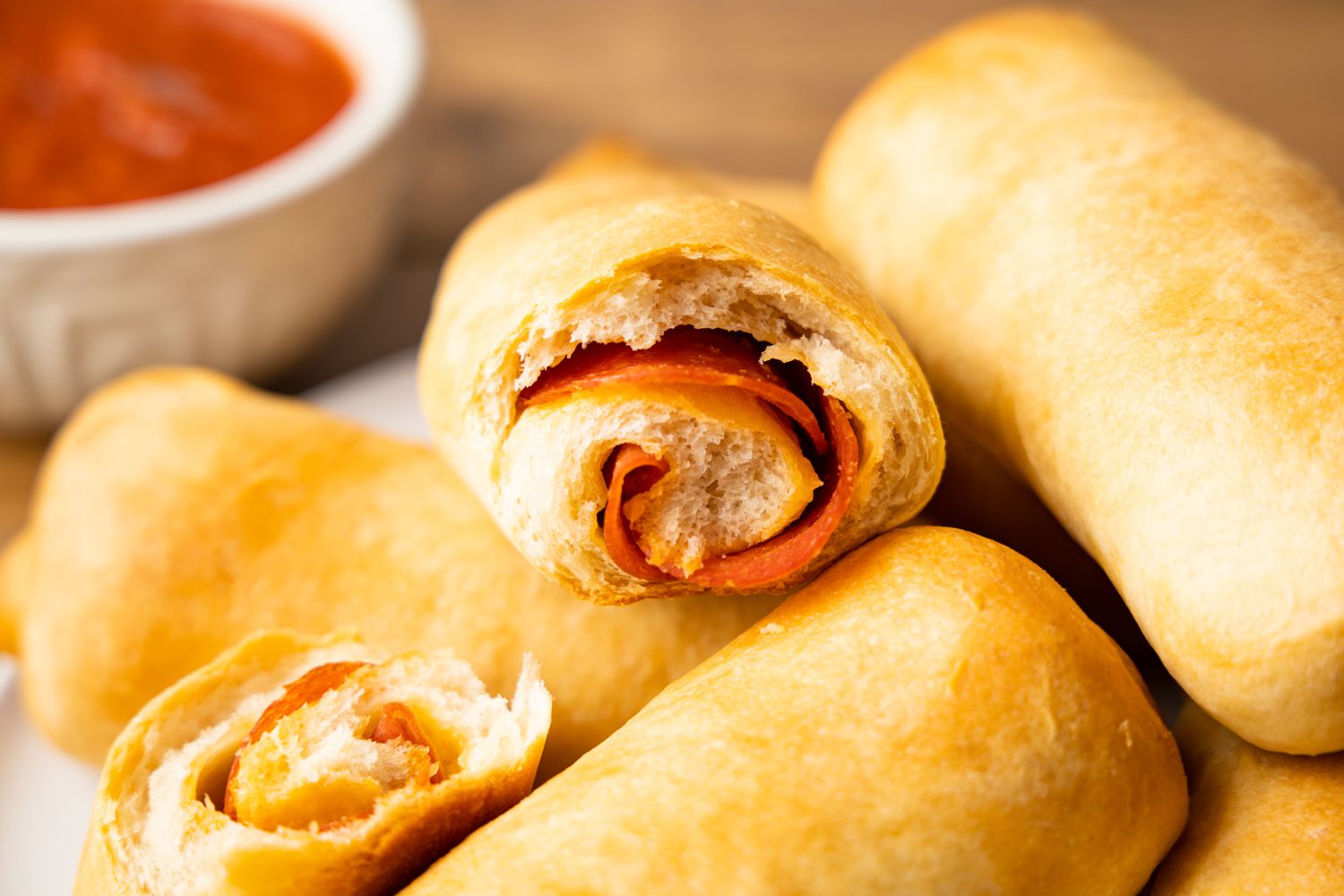 Pepperoni Rolls on a Plate Next to Bowl of Marinara