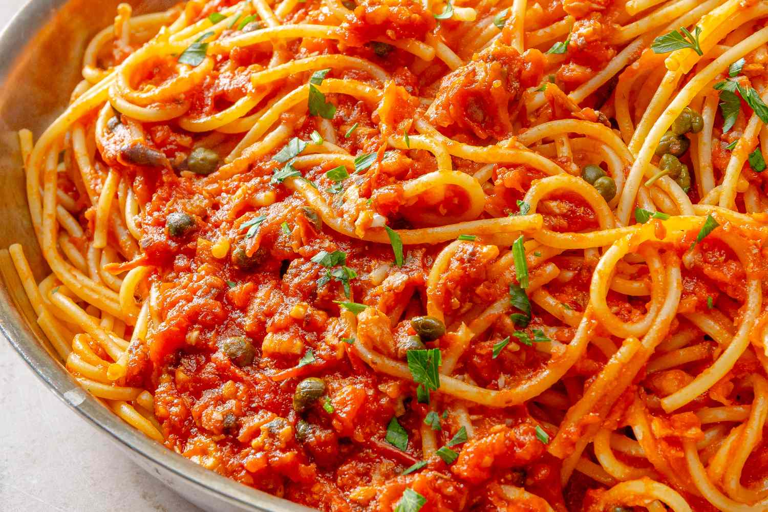 A pasta dish with sardine and tomato sauce garnished with herbs
