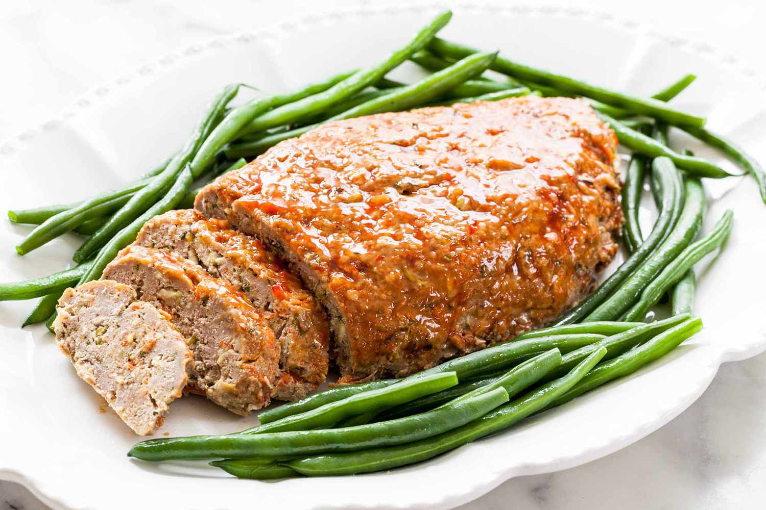 Turkey Meatloaf on a platter, surrounded by green beans