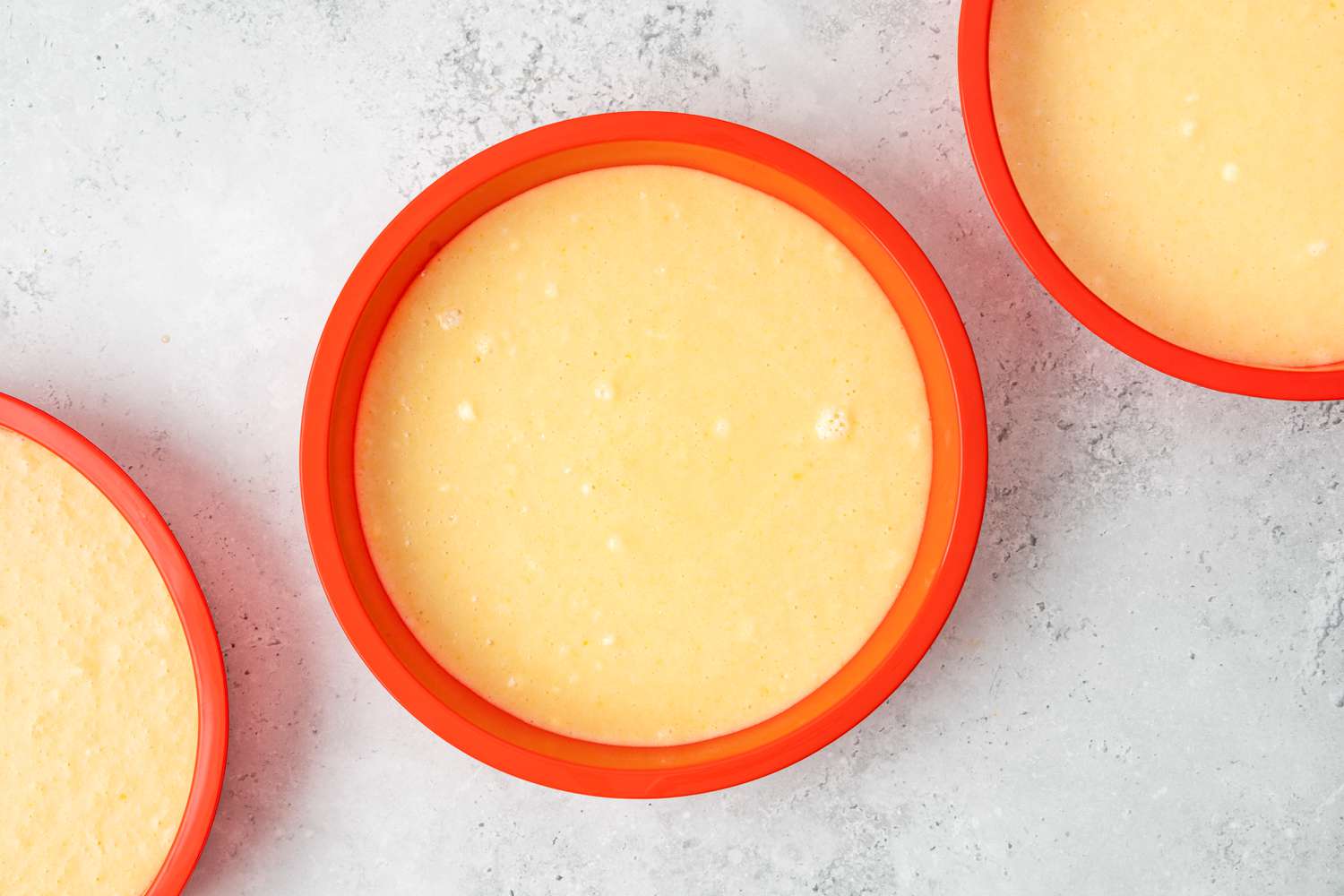 Batter for Cake In the Microwave Recipe Poured into Three Round Silicone Baking Pans 