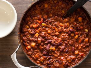 A pot with chili on a wooden surface
