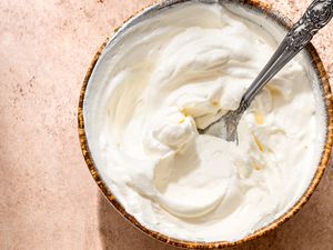 A bowl of whipped cream with a spoon in it