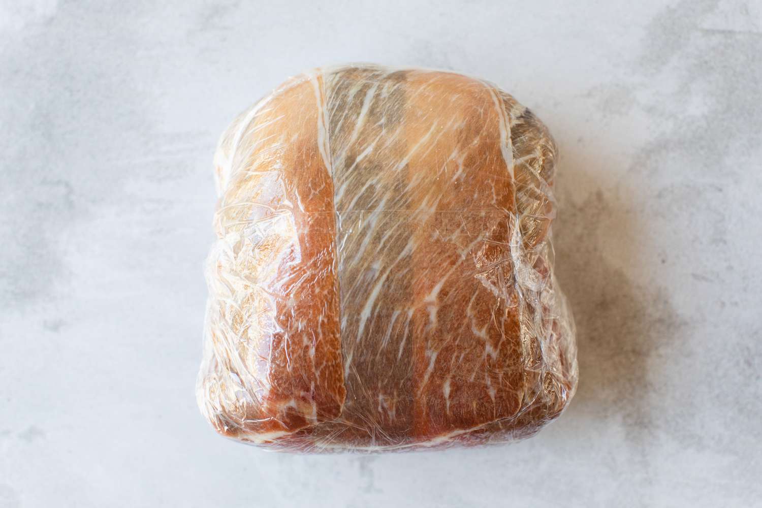 Prosciutto and Mushroom Duxelles Rolled Over Beef Fillet and Completely Wrapped in Plastic Wrap