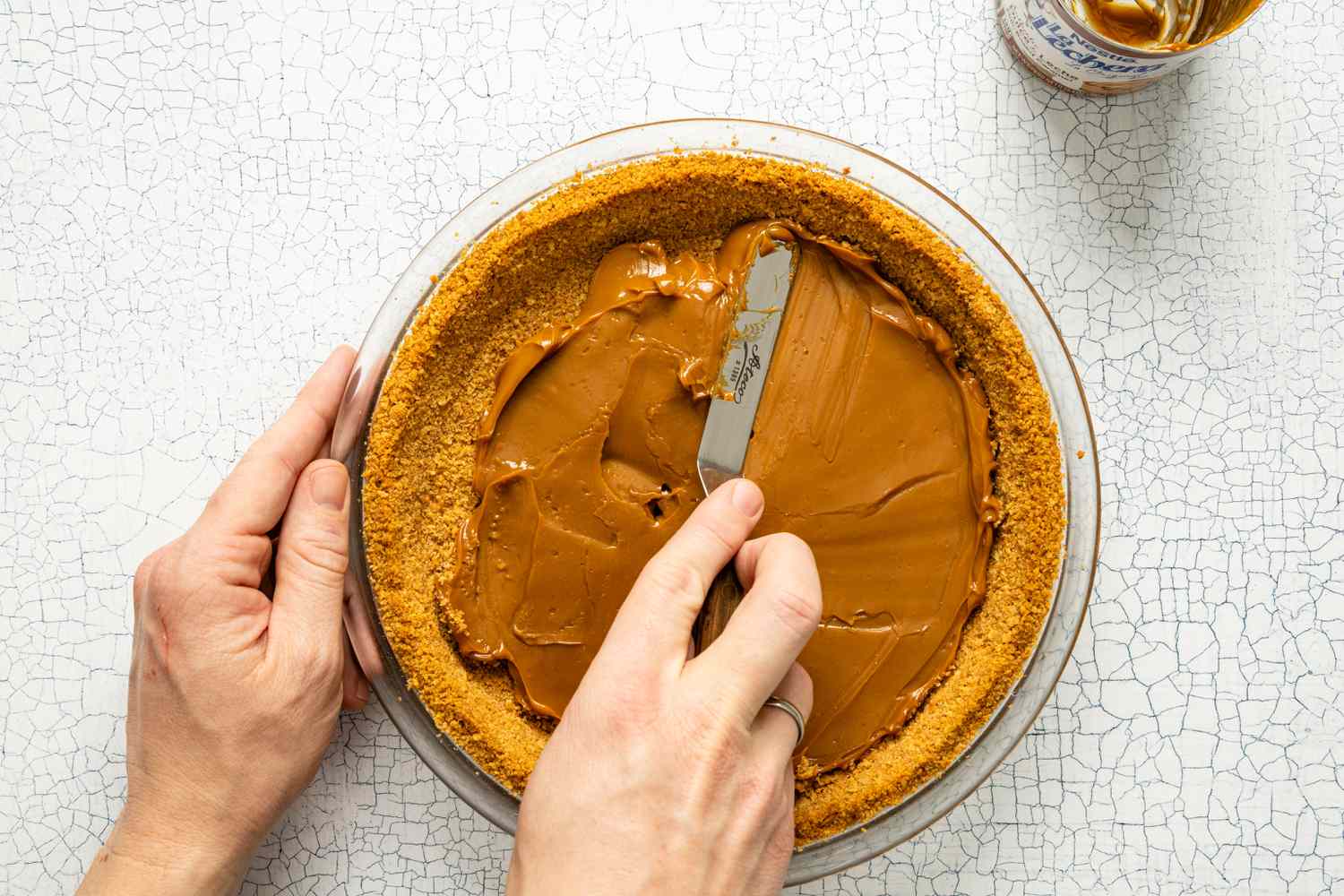 Dulce de Leche Spread onto the Pie Crust Using an Offset Spatula 