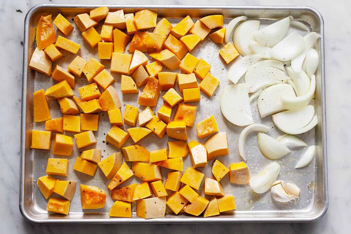 Butternut Squash and onions on a roasting pan.