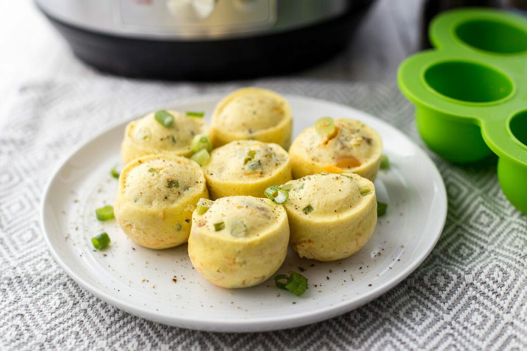 Finished pressure cooker egg bites on a plate with the instant pot in the background
