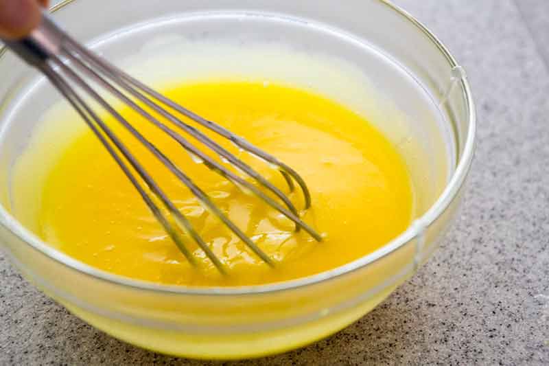 Lemon meringue pie filling in bowl with whisk