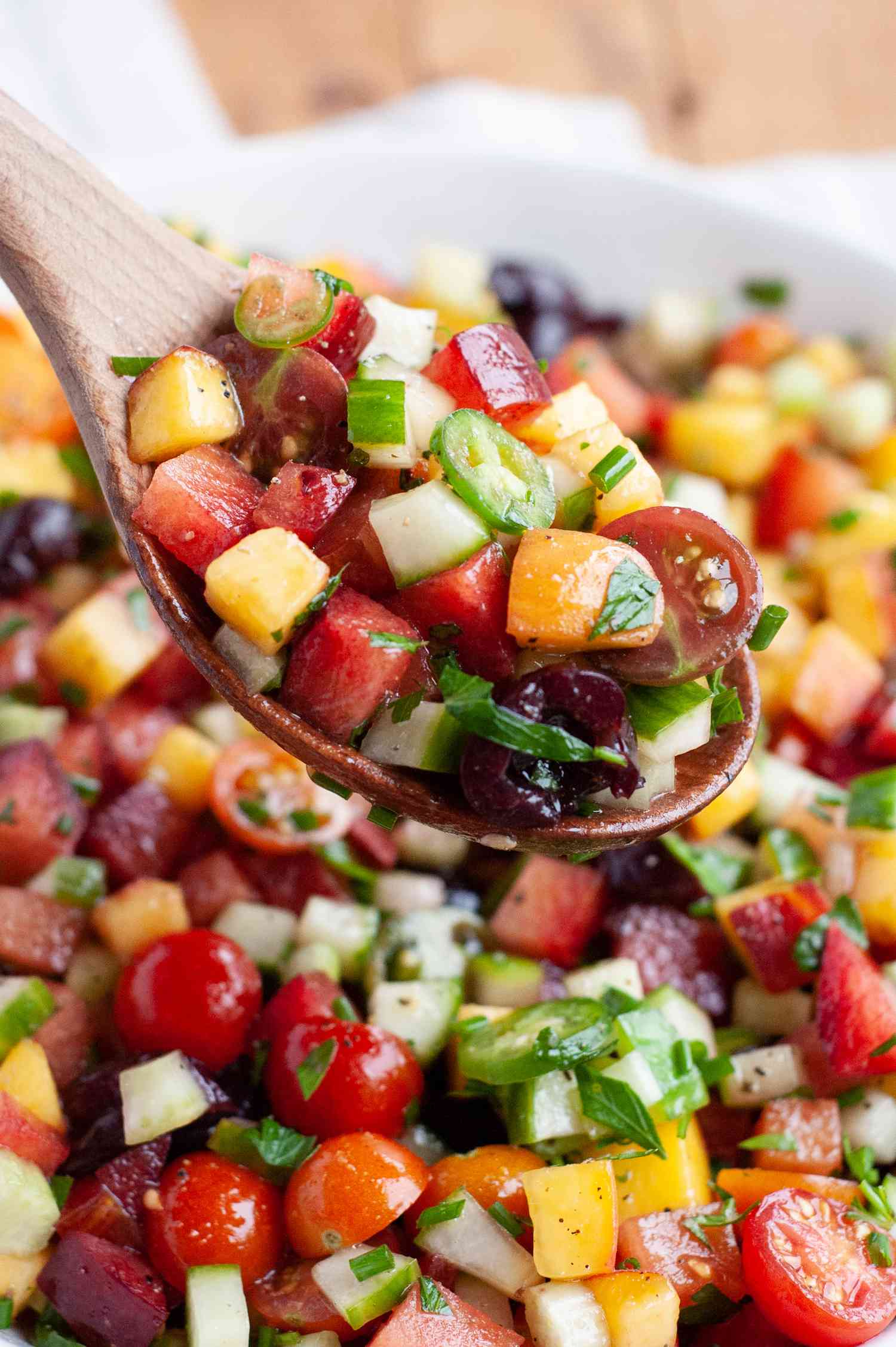 Herby fruit salad scooped with a spoon.