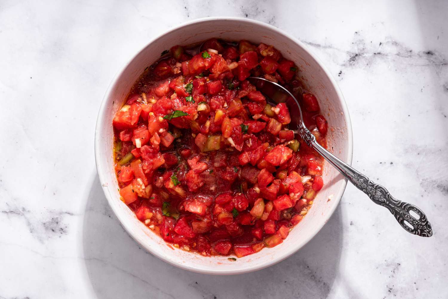 Diced tomatoes mixed with bruschetta ingredients (basil and olive oil) for bruschetta with tomato and basil recipe