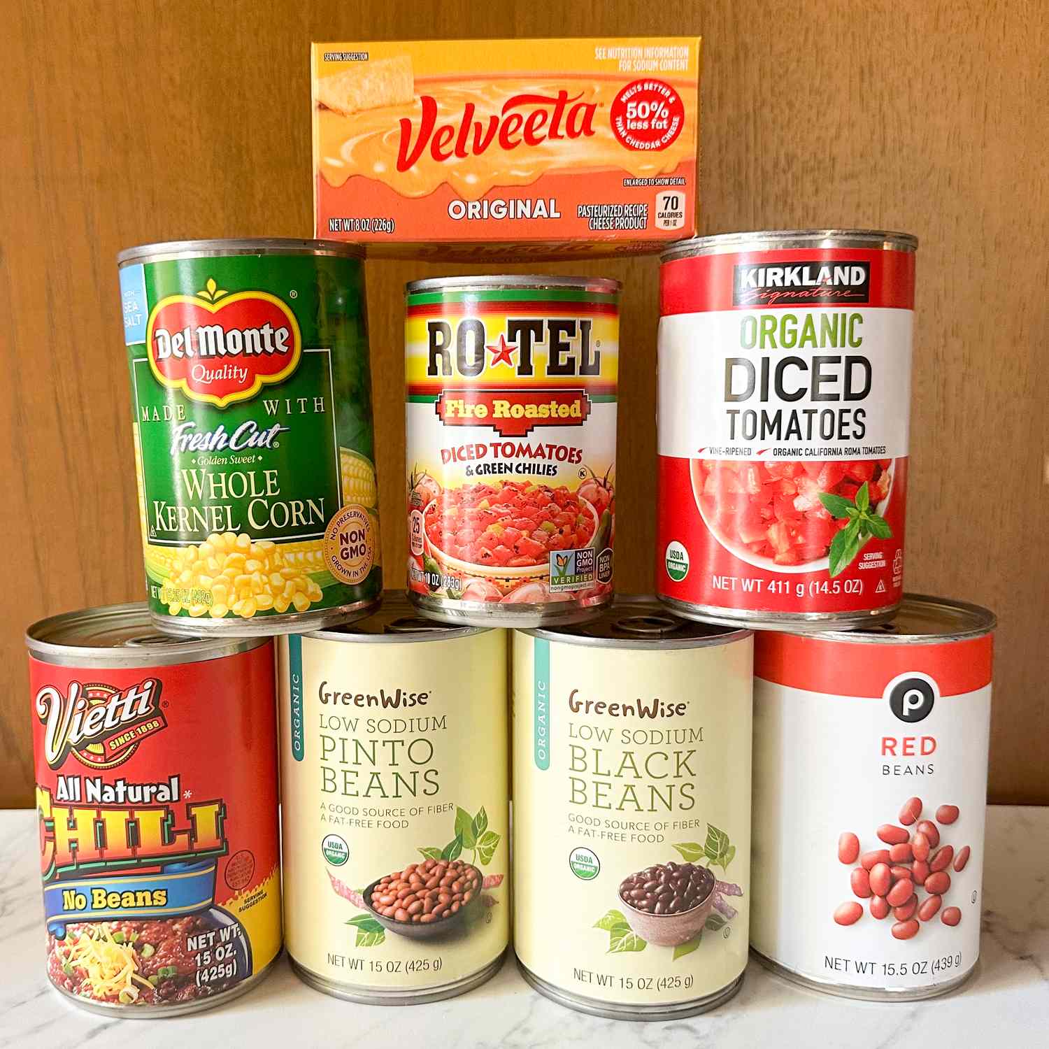 A selection of canned and packaged food items including corn diced tomatoes beans chili and Velveeta cheese
