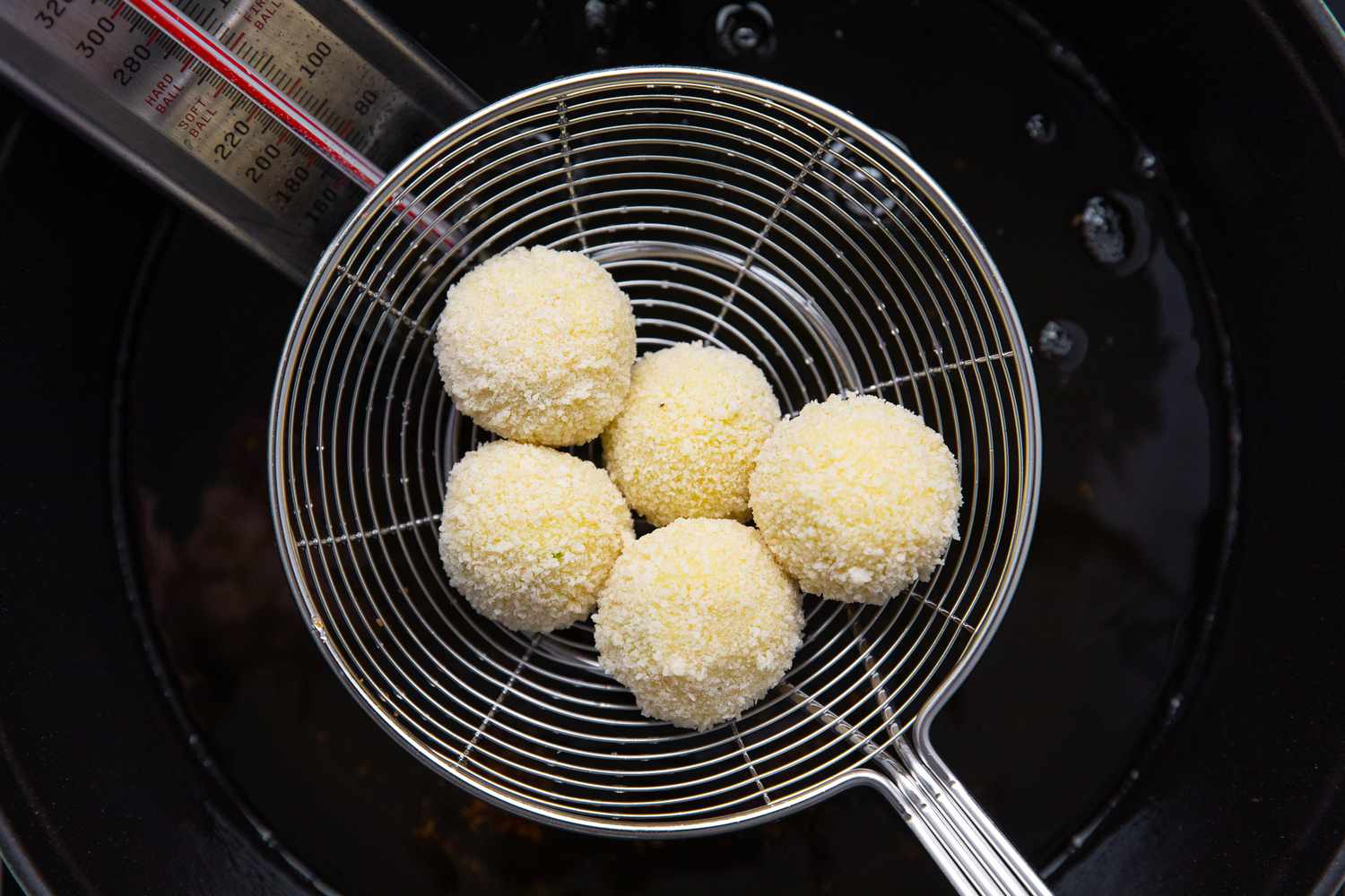 Potato Croquettes Lowered into Hot Oil Using a Spider 