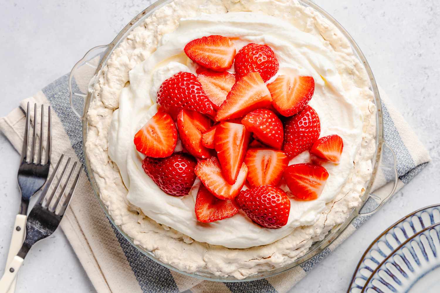 Soda cracker pie in a pie dish topped with whipped cream and sliced raspberries 