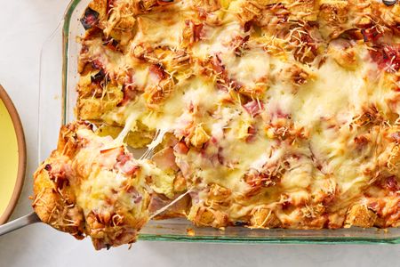 Croque monsieur breakfast casserole topped with melted cheese served in a glass baking dish