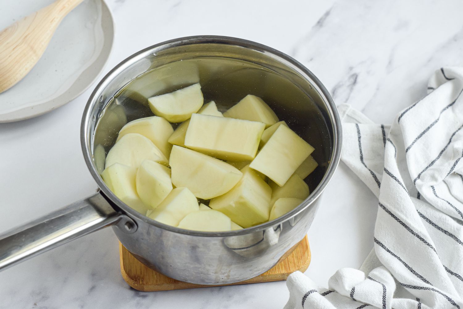 Pot of Peeled Potatoes and Water for Perfect Mashed Potatoes Recipe