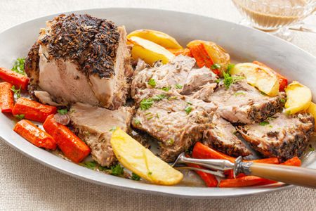 A platter with pork shoulder, carrots and potatoes.
