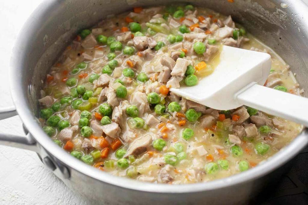 Add chopped turkey to bowl with vegetables for leftover turkey pot pie recipe