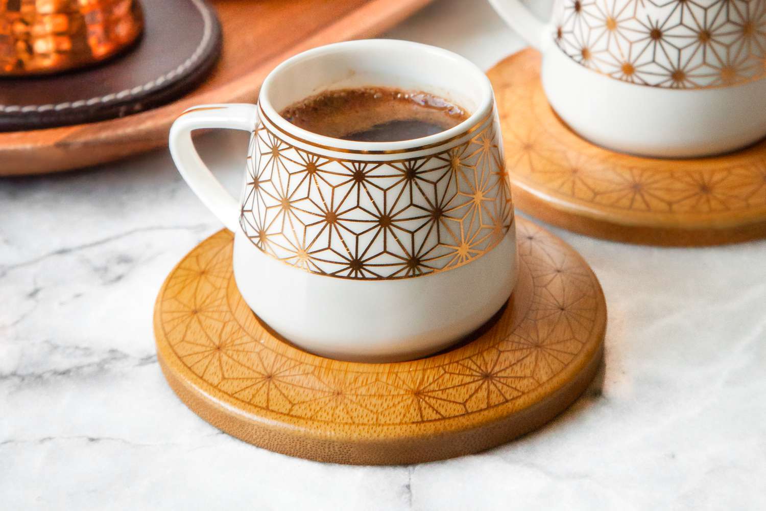 Cup of Turkish Coffee on a Coaster, and Next to It, Another Cup with More 