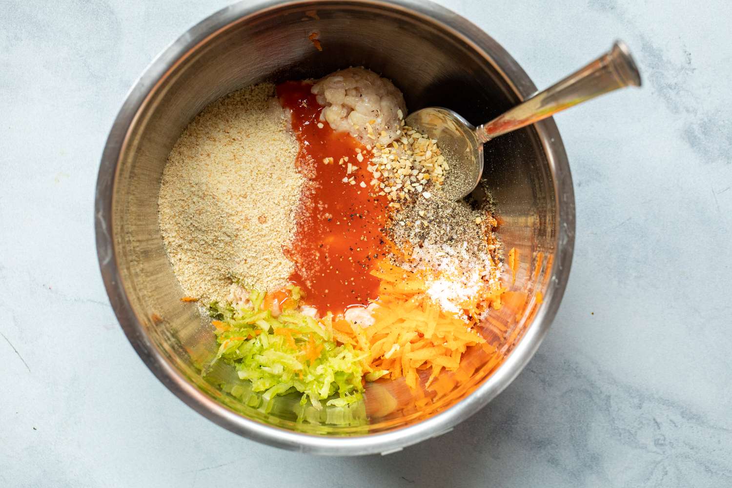 A metal bowl with ingredients to make buffalo chicken burgers.