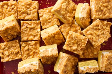 Salted nut roll bars cut into squares arranged on a surface