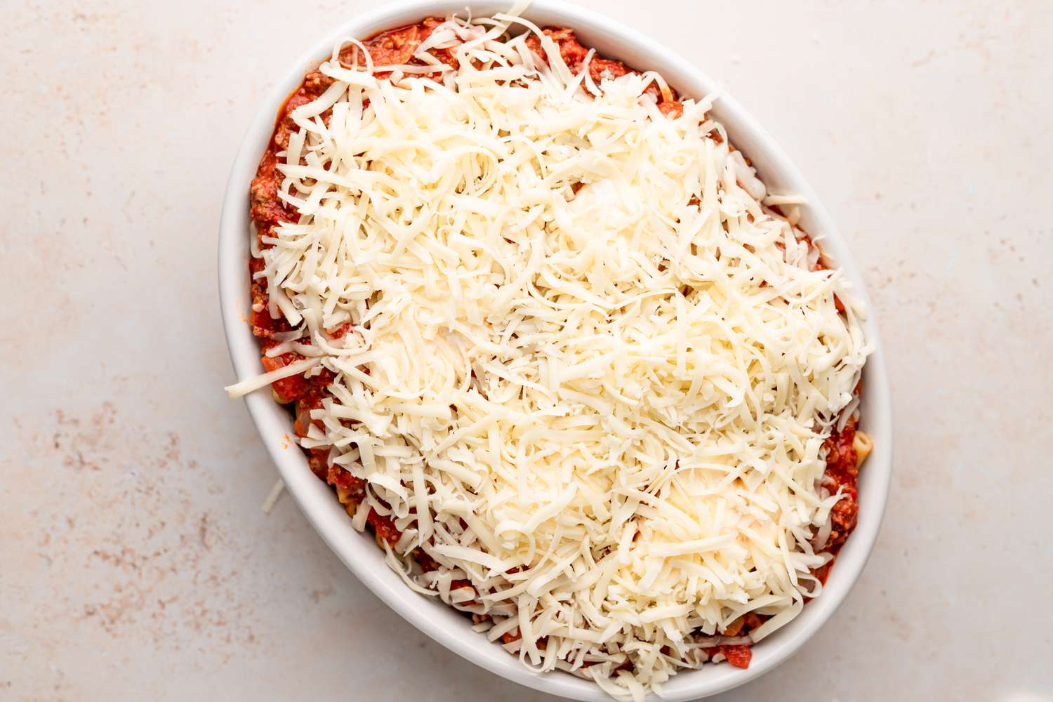 Shredded cheese topping a pasta bake.