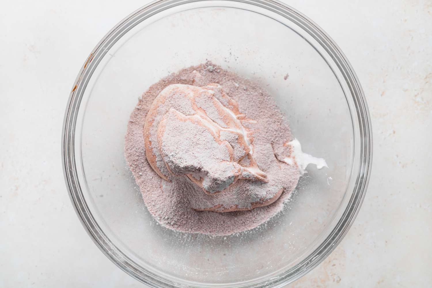 Adding meringue to dry ingredients to make macarons.